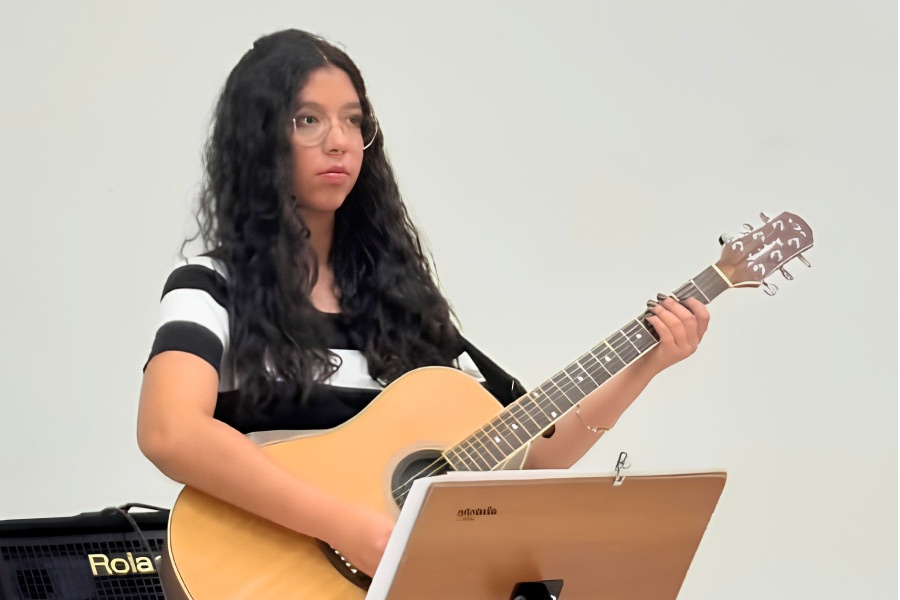 Ana Luiza tocando violão na banda da igreja